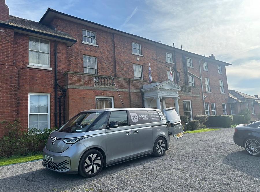 The silver TD Exterior Cleaning van parked on the gravel drive of a red brick Georgian house in Shropshire.