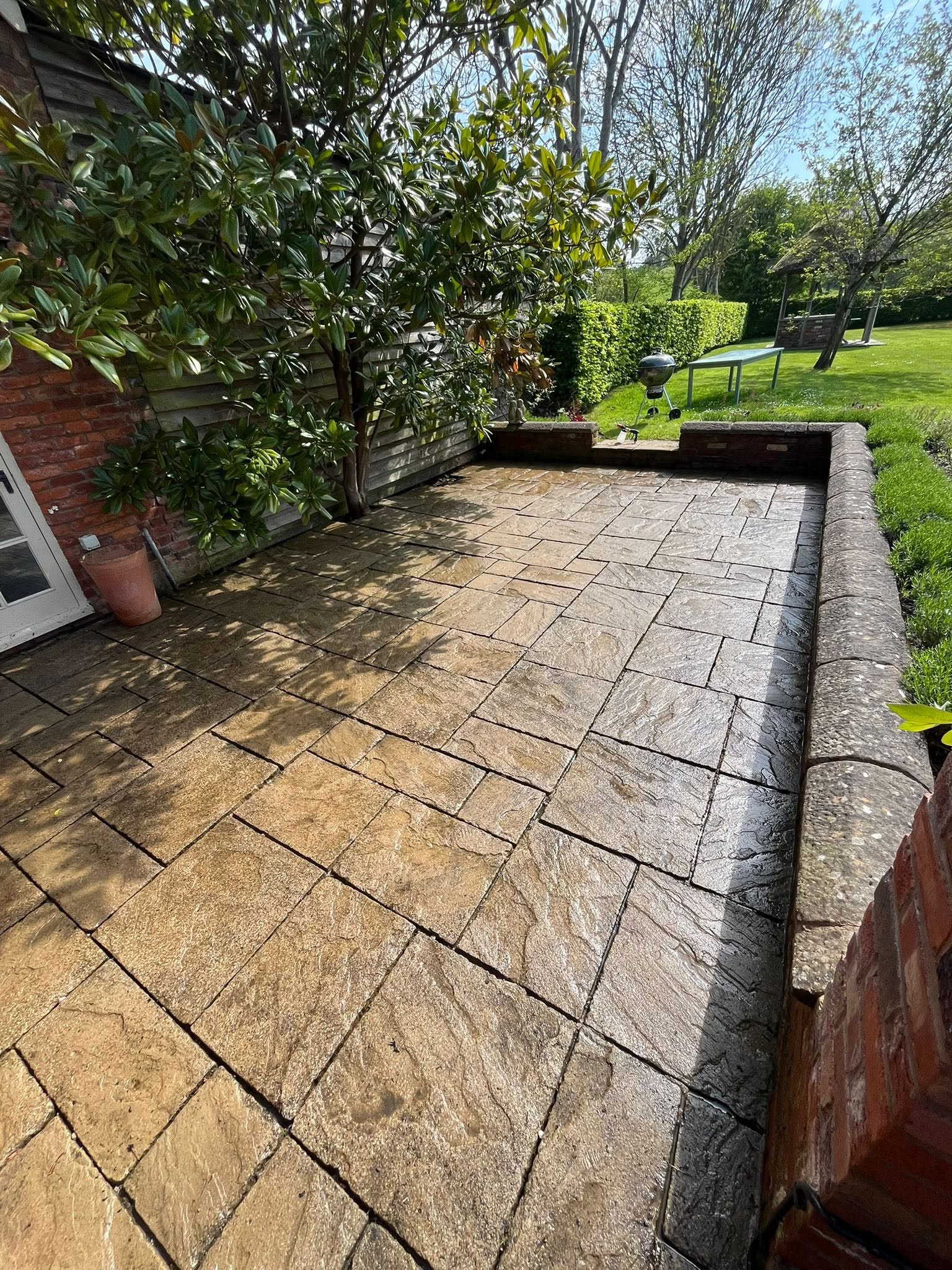 A walled garden patio in Shropshire restored to clean, warm sandstone by TD Exterior Cleaning